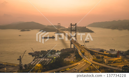 Iconic Suspension Bridge Illuminated At Sunset Over Tranquil Waters Feb 21 2026 137734228