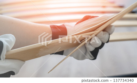 broken lamella on the bed.The master changes lamella on the bed. Broken lamella close-up by the bed. broken lamella on the bed.The master changes lamella on the bed. Broken lamella close-up by the bed. 137734340