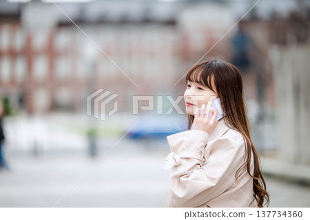 一位女商人外出時正在打電話。 一位女商人外出時正在打電話。 137734360