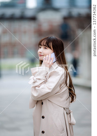 一位女商人外出時正在打電話。 137734362