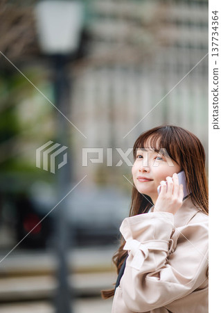 A businesswoman making a phone call while out and about. 137734364