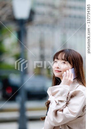 一位女商人外出時正在打電話。 137734365