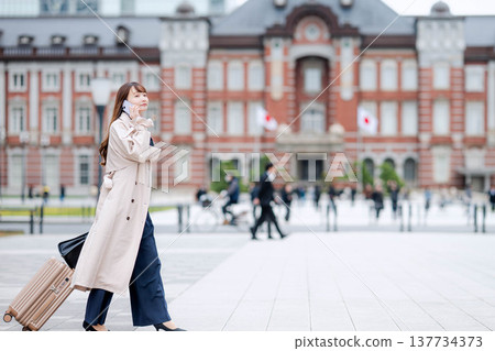 一位女商人外出時正在打電話。 137734373