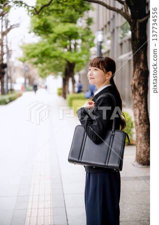 Young women commuting to work in suits Young women commuting to work in suits 137734556