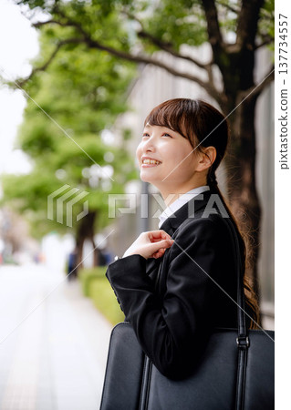 Young women commuting to work in suits Young women commuting to work in suits 137734557