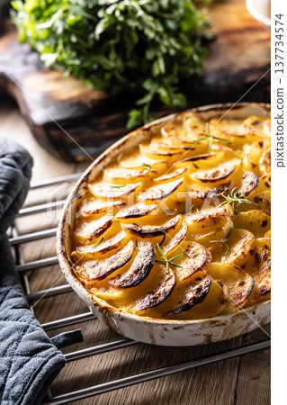 Golden-brown gratin potatoes, neatly arranged in a white ceramic bowl and garnished with fresh herbs. In Slovakia, however, this dish is known primarily at home as French potatoes Golden-brown gratin potatoes, neatly arranged in a white ceramic bowl and garnished with fresh herbs. In Slovakia, however, this dish is known primarily at home as French potatoes 137734574