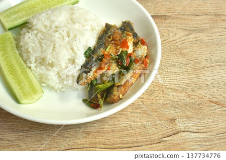 spicy stir fried mackerel with basil and fresh chili on plain rice eat couple slice cucumber on dish 137734776