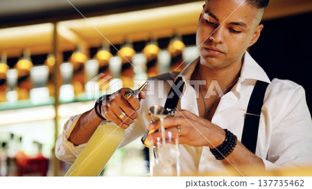 Bartender making cocktail using jigger at illuminated bar 137735462