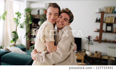 Gay couple happily hugging sharing intimate moment at home 137735491
