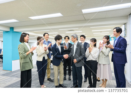 寬敞的辦公室裡，一大群男女商務人士鼓掌。 137735701