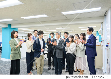 寬敞的辦公室裡，一大群男女商務人士鼓掌。 137735702