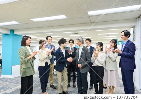 寬敞的辦公室裡，一大群男女商務人士鼓掌。 137735704