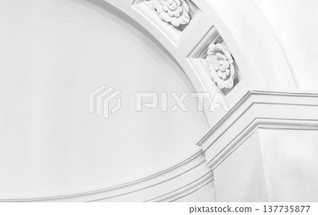 A refined white arch and decorative molding detail with floral rosettes A refined white arch and decorative molding detail with floral rosettes 137735877