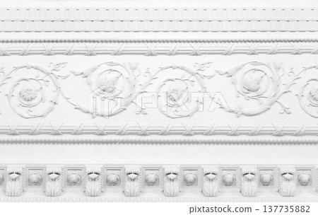 Intricate white plaster ornamentation with scrolling floral vines and rosettes Intricate white plaster ornamentation with scrolling floral vines and rosettes 137735882