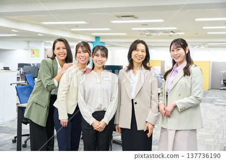 A group photo of five female employees smiling and looking at the camera, conveying a sense of teamwork. (Office) A group photo of five female employees smiling and looking at the camera, conveying a sense of teamwork. (Office) 137736190