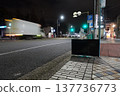 Unwanted items left on the sidewalk at night and the urban traffic scene. 137736773