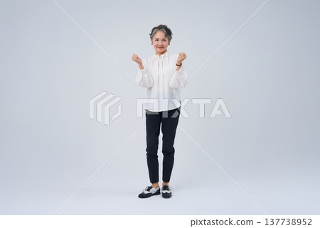 Senior woman strikes a cheering pose Senior woman strikes a cheering pose 137738952