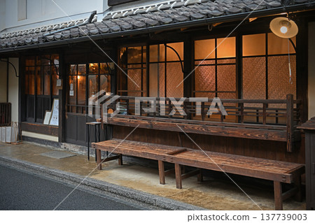 溫暖宜人的燈光從一家翻新的老房子咖啡館的店面傾瀉而出,這家咖啡館坐落在內子區一條街道旁,內子區被指定為傳統建築群重要保護區。 溫暖宜人的燈光從一家翻新的老房子咖啡館的店面傾瀉而出,這家咖啡館坐落在內子區一條街道旁,內子區被指定為傳統建築群重要保護區。 137739003