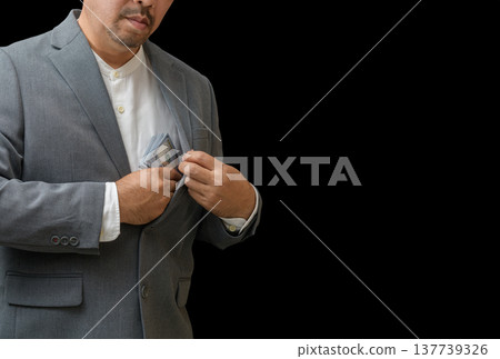 Businessman Putting Cash into Suit Pocket on Black Background Businessman Putting Cash into Suit Pocket on Black Background 137739326