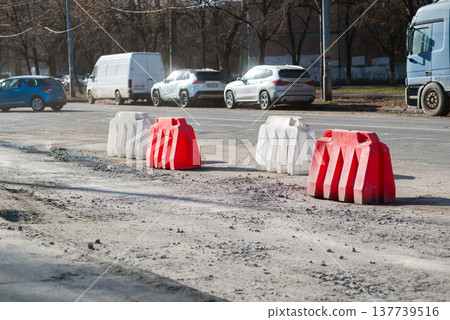 Road repair barriers marking damaged asphalt on city street, traffic safety and infrastructure maintenance. Road repair barriers marking damaged asphalt on city street, traffic safety and infrastructure maintenance. 137739516