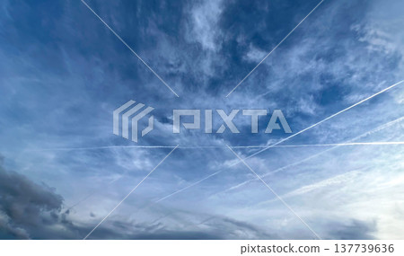 View of aircraft contrails and cloud clouds against blue sky View of aircraft contrails and cloud clouds against blue sky 137739636