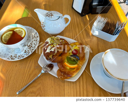 View of the table set for breakfast with hot drinks and sweet pastries View of the table set for breakfast with hot drinks and sweet pastries 137739640