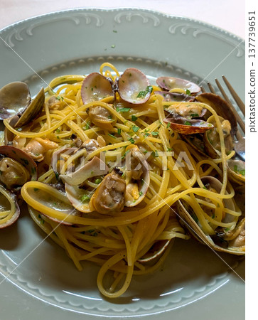 View of a round plate with Italian pasta vongole on a trattoria table in Italy View of a round plate with Italian pasta vongole on a trattoria table in Italy 137739651