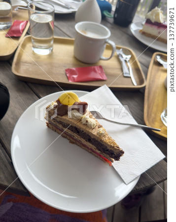 A large delicious piece of cake, coffee and a glass of water on a wooden table 137739671