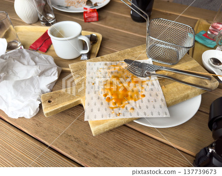 Empty dirty various dishes and used napkins on a wooden table in cafe after meal Empty dirty various dishes and used napkins on a wooden table in cafe after meal 137739673