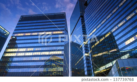Osaka, Japan - Sep 25 2024, panoramic view from below of the reflecting glass facades of skyscrapers, lights are on on some floors, in Umeda district, at night, without people, Osaka, Japan 137739768