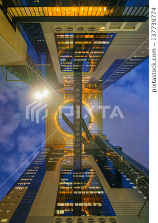 Osaka, Japan - Sep 25 2024, panoramic view from bottom to top of the illuminating ring between the two towers of Umeda Sky Building, in the evening with cloudy sky, Osaka, Japan Osaka, Japan - Sep 25 2024, panoramic view from bottom to top of the illuminating ring between the two towers of Umeda Sky Building, in the evening with cloudy sky, Osaka, Japan 137739774