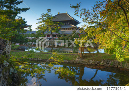 Nara, Japan - Sep 26 2024, Panoramic view across the pond and trees to the facade of Todaiji Temple, Great Buddha Hall, with a blue cloudy sky, Nara, Japan Nara, Japan - Sep 26 2024, Panoramic view across the pond and trees to the facade of Todaiji Temple, Great Buddha Hall, with a blue cloudy sky, Nara, Japan 137739841