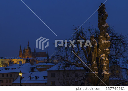 Prague Castle overseeing Charles Bridge with snowy Baroque statue at night Prague Castle overseeing Charles Bridge with snowy Baroque statue at night 137740681