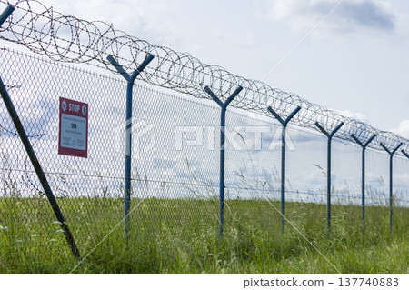 Barbed wire fence marking a secured restricted area in Hostivice 137740883