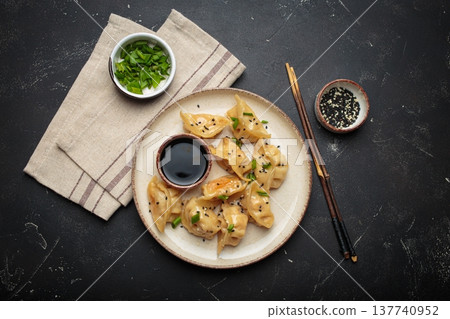 Gyoza dumplings soy sauce chopsticks asian Japanese food wontons black background 137740952