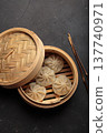 Chinese food dim sum bao dumplings bamboo steamer chopsticks black background 137740971