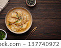 Gyoza dumplings broth soup chopsticks wooden background bowl asian wontons 137740972