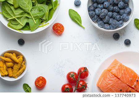 Healthy anti inflammatory diet food ingredients white background salmon blueberry spinach copy space 137740973