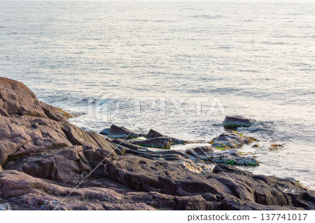 black sea coast background with rugged rock formation during summer. stone and water texture in morning light. remote place for relax. seaside picture from sozopol bay, bulgaria on a sunny weather 137741017