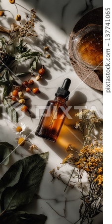 Amber dropper bottle with dried botanicals for natural remedies. Amber dropper bottle with dried flowers and herbs on white marble surface for beauty and wellness Amber dropper bottle with dried botanicals for natural remedies. Amber dropper bottle with dried flowers and herbs on white marble surface for beauty and wellness 137741065