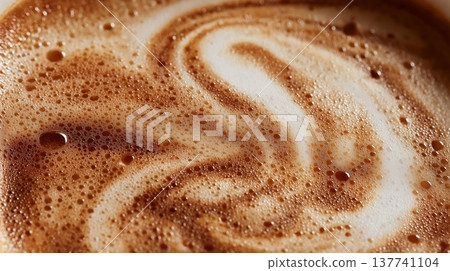 Coffee foam texture creating swirling latte art patterns. Coffee foam showing a close-up texture creating swirling latte art patterns 137741104