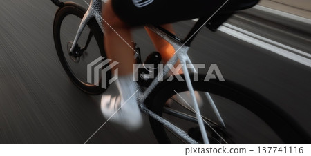 Cyclist propelling modern road bike forward on asphalt road. Cyclist riding bicycle with motion blur, emphasizing speed, fitness, and movement 137741116