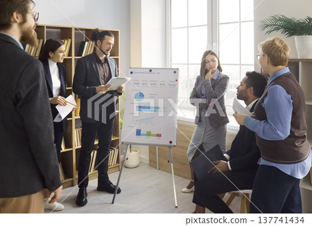 Business team training with coach at flipchart in office meeting presentation Business team training with coach at flipchart in office meeting presentation 137741434
