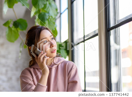 婦女在窗邊打電話 137741442