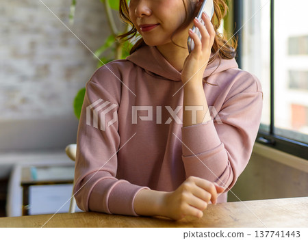 一名女子正在室內用手機通話。 137741443