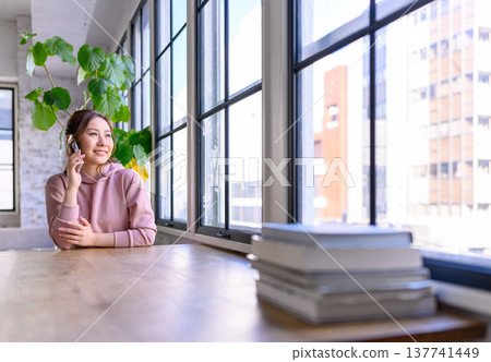 一個女人在窗邊打電話 137741449
