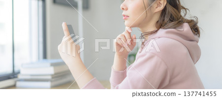 A woman stares at her smartphone and thinks. A woman stares at her smartphone and thinks. 137741455