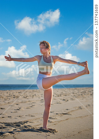 Woman yoga practice at the beach in Utthita Hasta Padangusthasana Extended Hand-to-Big-Toe Pose Woman yoga practice at the beach in Utthita Hasta Padangusthasana Extended Hand-to-Big-Toe Pose 137741689