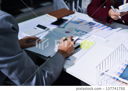 Business people analyzing monthly budget and financial report using data and chart to strategize and plan for their future business while working together in the office. Business people analyzing monthly budget and financial report using data and chart to strategize and plan for their future business while working together in the office. 137741788