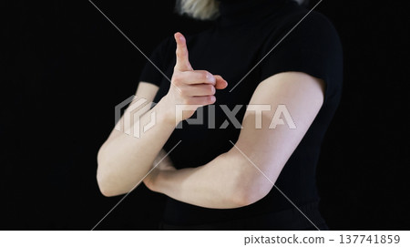 Confident Female Hand Pointing Forward in Minimal Studio Setting on Black Background, Concept of Attention and Direction Confident Female Hand Pointing Forward in Minimal Studio Setting on Black Background, Concept of Attention and Direction 137741859
